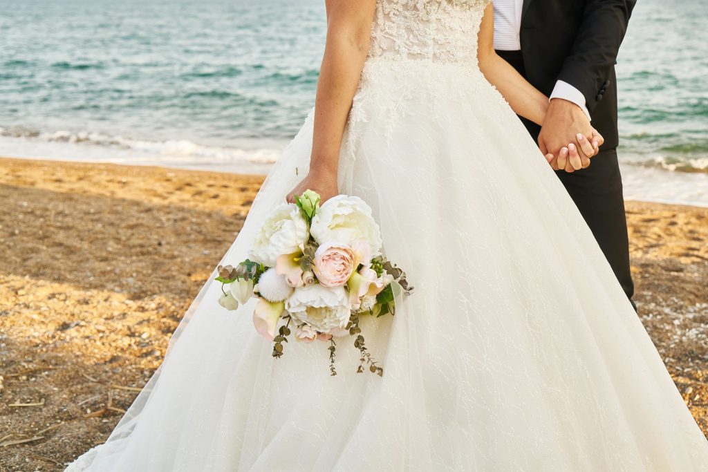Jeunes mariés en tenues de mariage sur la plage
