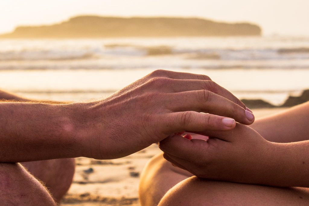Couple se tenant la main sur la plage