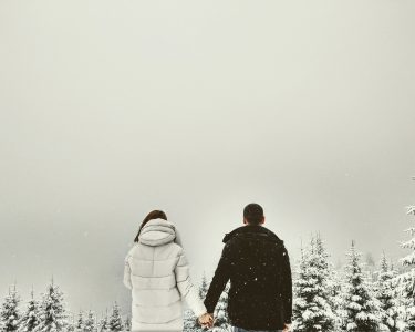 Couple se tenant la main sous la neige